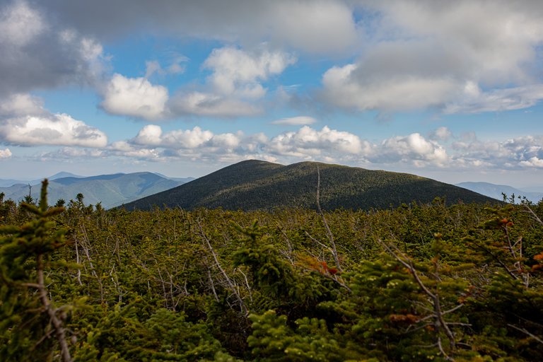 Mount Bond ridge with forest under scattered clouds in White Mountains