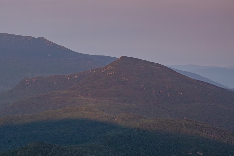 Mount Garfield peak at dawn with soft light and layered forest ridges in New Hampshire