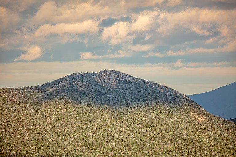 Mount Liberty ridge with granite ledges and forest under soft sunset clouds