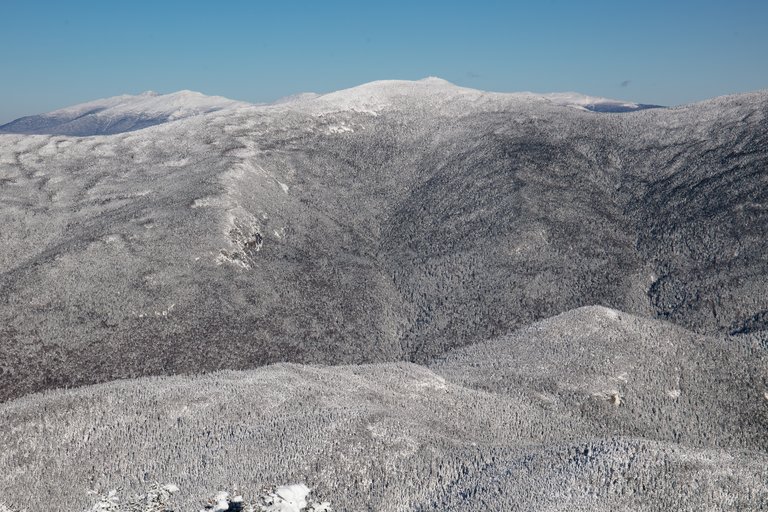 Snow-covered North Twin Mountain ridge in winter with clear blue sky