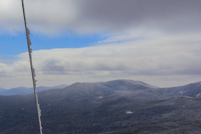 South Kinsman Mountain frosted ridge under cloudy spring sky in White Mountains New Hampshire