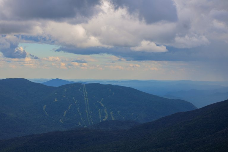 Wildcat Mountain D with cloud shadows and forested slopes at sunset in White Mountains