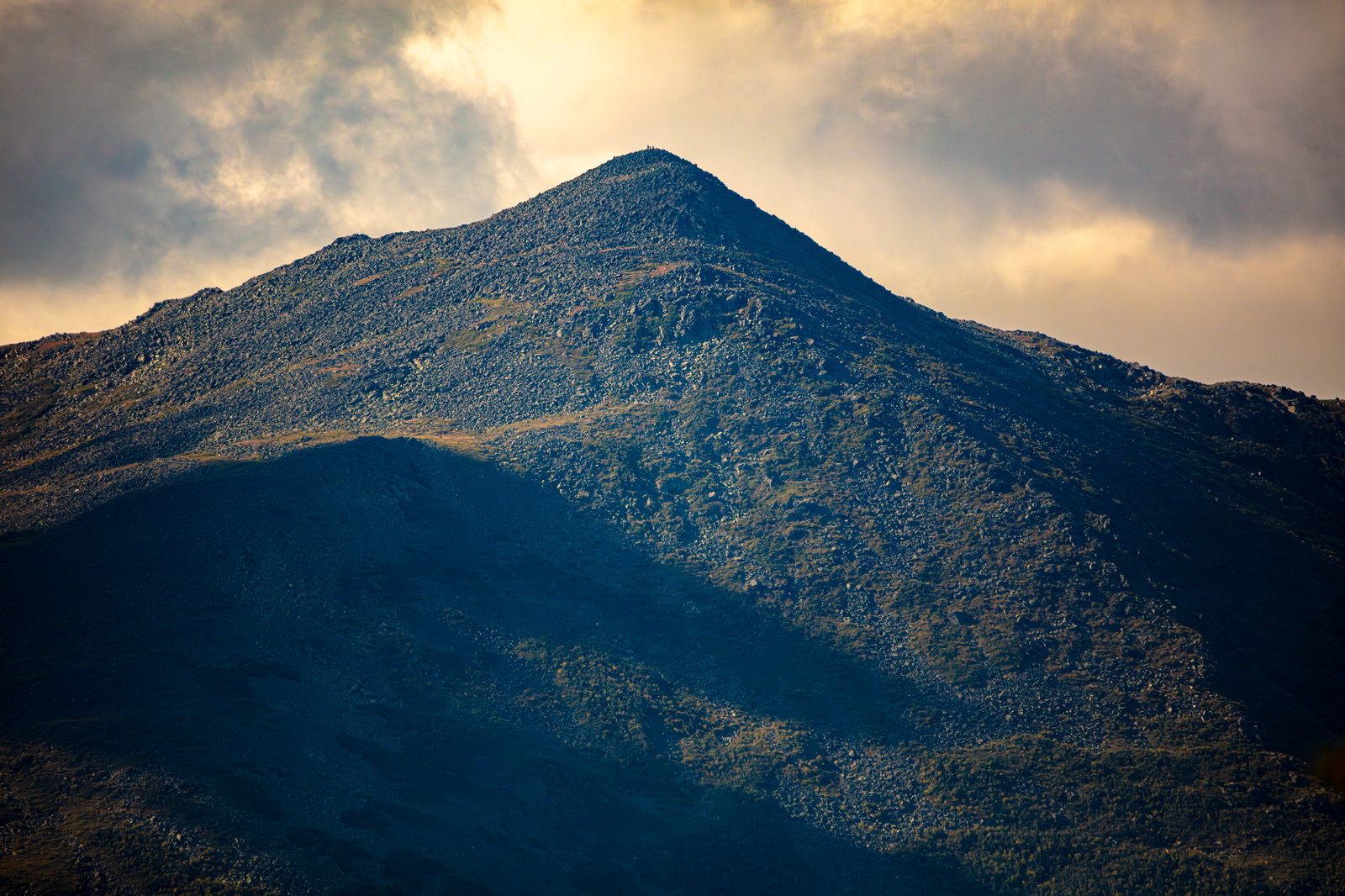 Mount Adams granite slopes glowing in afternoon sunlight under cloudy sky