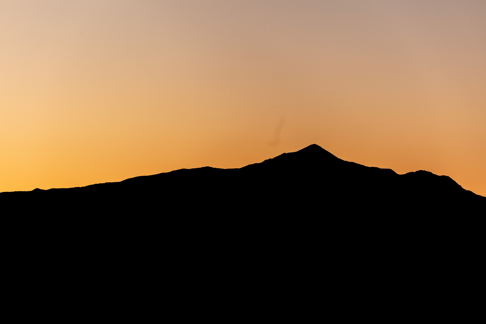 Silhouette of Mount Adams at sunset with orange sky in White Mountains