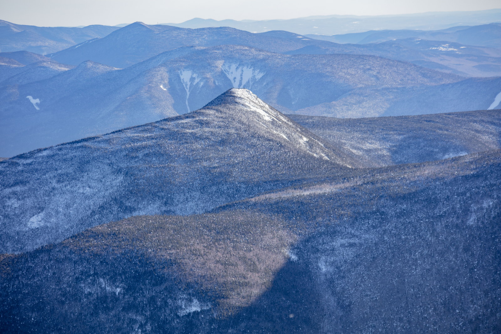 Snow-dusted Mount Flume peak under soft winter afternoon light in White Mountains