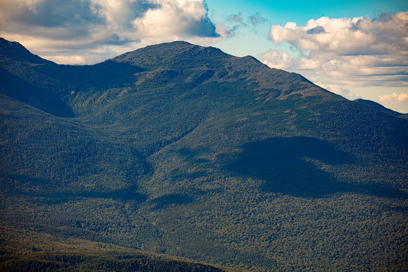 Mount Madison peak with forested slopes and cloud shadows in White Mountains New Hampshire