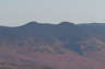 Forested mountain ridge and summit of Middle Tripyramid in the White Mountain National Forest under a partly cloudy sky.