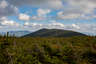Forested mountain ridge and summit of Mount Bond in the White Mountain National Forest under a partly cloudy sky.