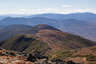 Forested mountain ridge and summit of Mount Eisenhower in the White Mountain National Forest under a partly cloudy sky.