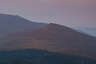 Forested mountain ridge and summit of Mount Garfield in the White Mountain National Forest under a partly cloudy sky.