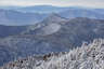 Forested mountain ridge and summit of Mount Hancock - South Peak. in the White Mountain National Forest under a partly cloudy sky.