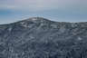 Forested mountain ridge and summit of Mount Jackson in the White Mountain National Forest under a partly cloudy sky.