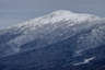 Forested mountain ridge and summit of Mount Jefferson in the White Mountain National Forest under a partly cloudy sky.
