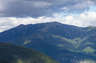 Forested mountain ridge and summit of Mount Lafayette in the White Mountain National Forest under a partly cloudy sky.
