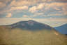 Forested mountain ridge and summit of Mount Liberty in the White Mountain National Forest under a partly cloudy sky.