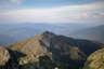 Forested mountain ridge and summit of Mount Madison in the White Mountain National Forest under a partly cloudy sky.