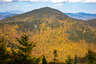 Forested mountain ridge and summit of Mount Passaconaway in the White Mountain National Forest under a partly cloudy sky.