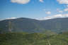 Forested mountain ridge and summit of North Twin Mountain in the White Mountain National Forest under a partly cloudy sky.