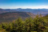 Forested mountain ridge and summit of Owl's Head in the White Mountain National Forest under a partly cloudy sky.