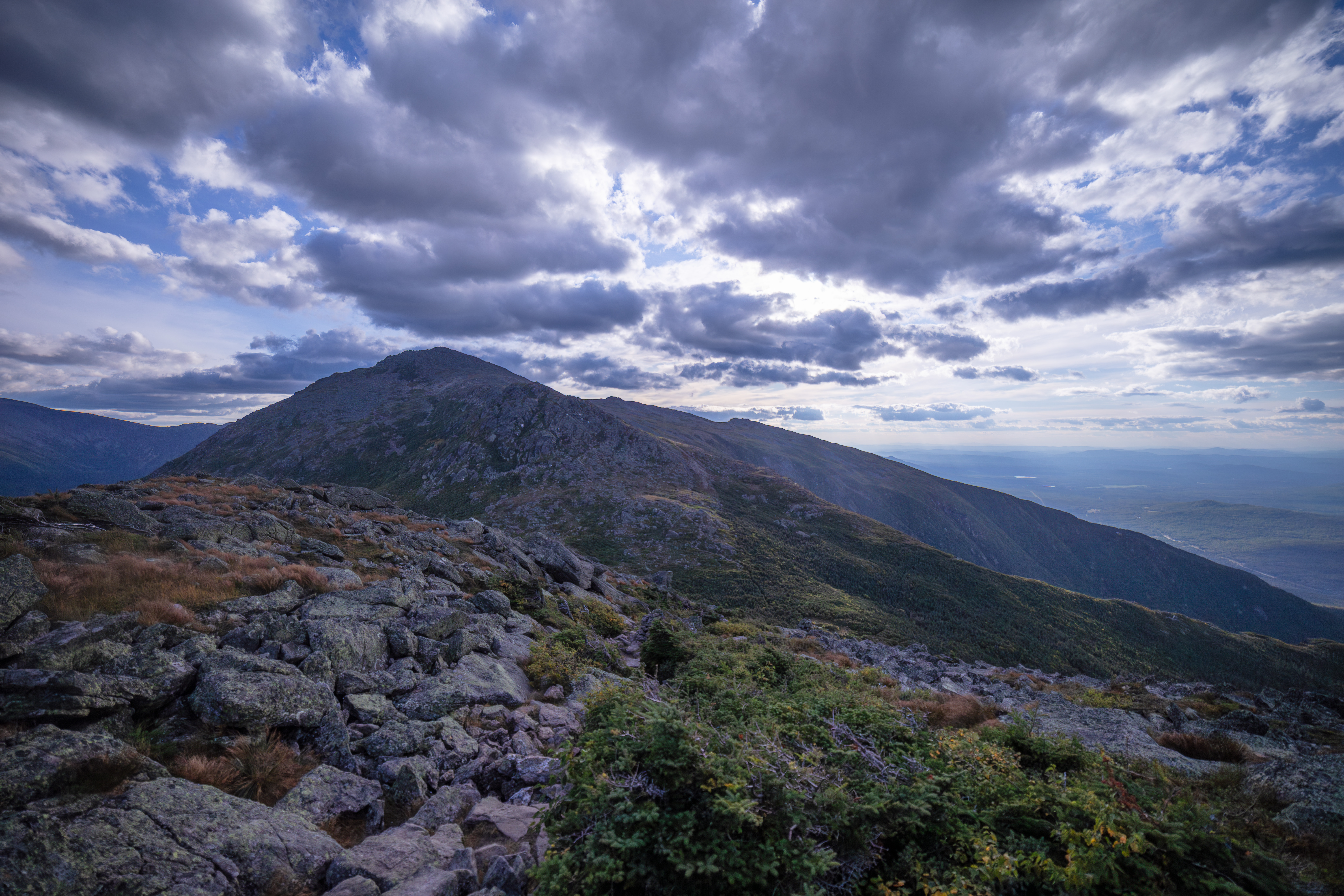 Forested mountain ridge and summit of Mount Adams in the White Mountain National Forest under a partly cloudy sky.
