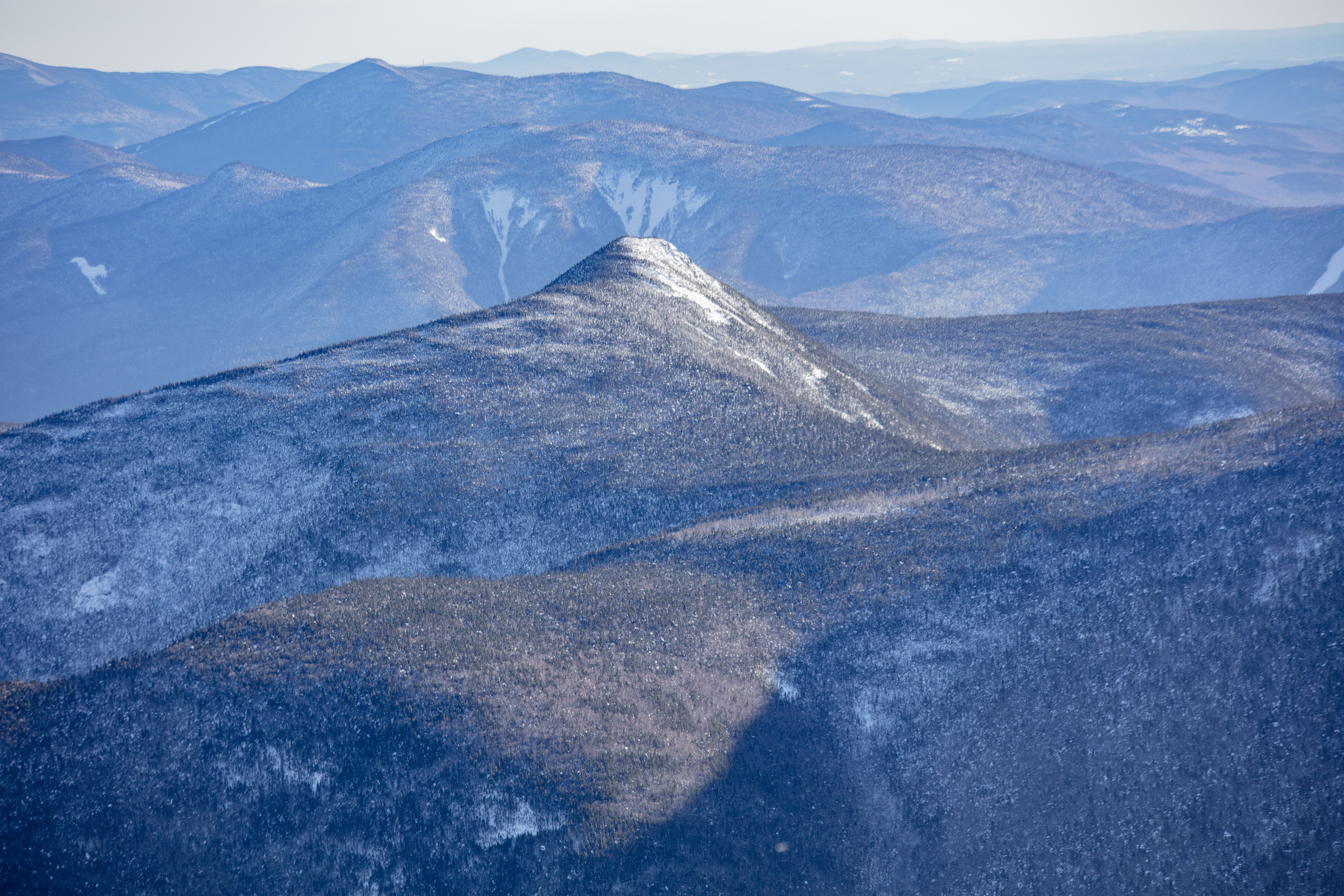 Snow-dusted Mount Flume peak under soft winter afternoon light in White Mountains