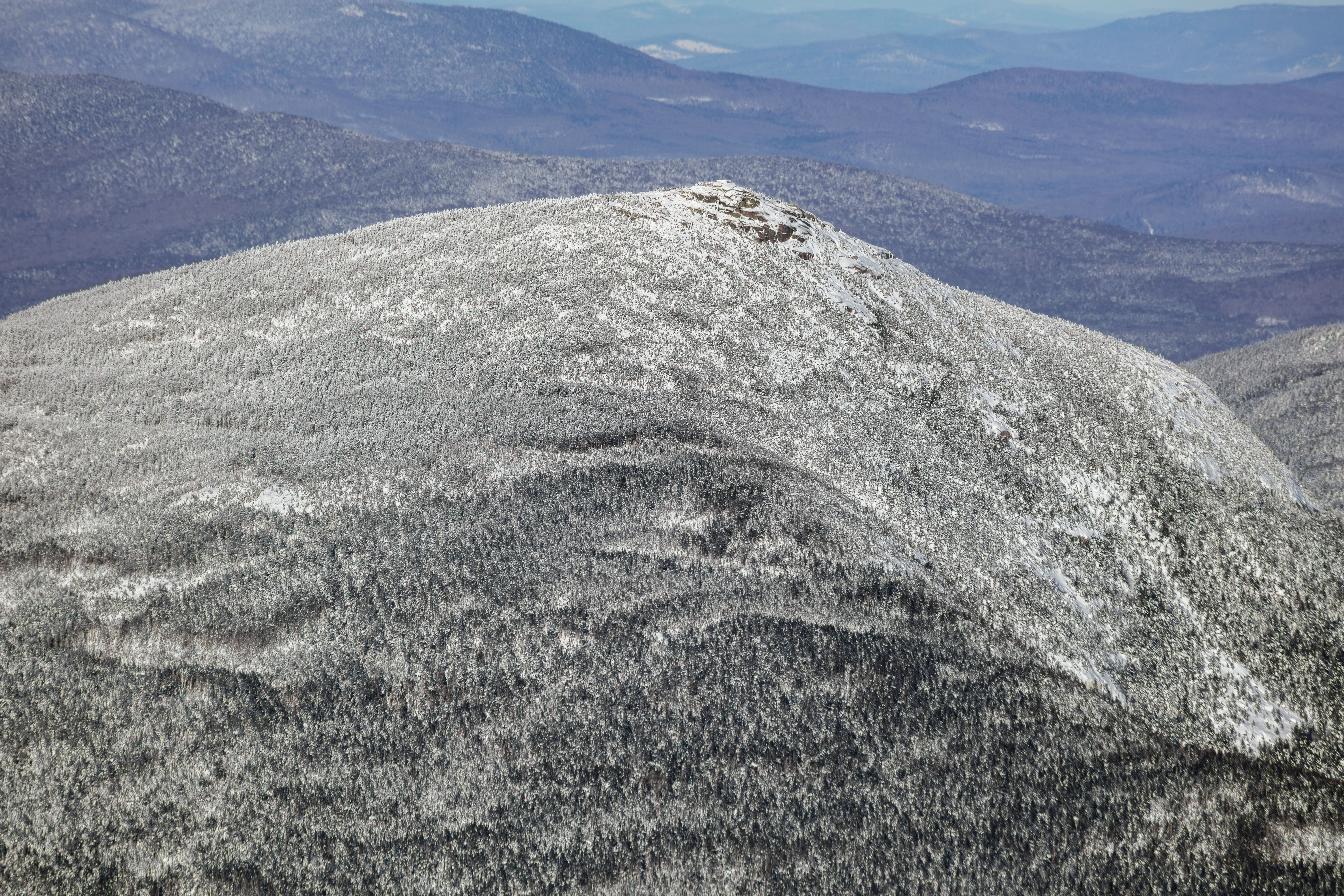 Snow-covered Mount Garfield summit in White Mountains, New Hampshire on a clear winter afternoon