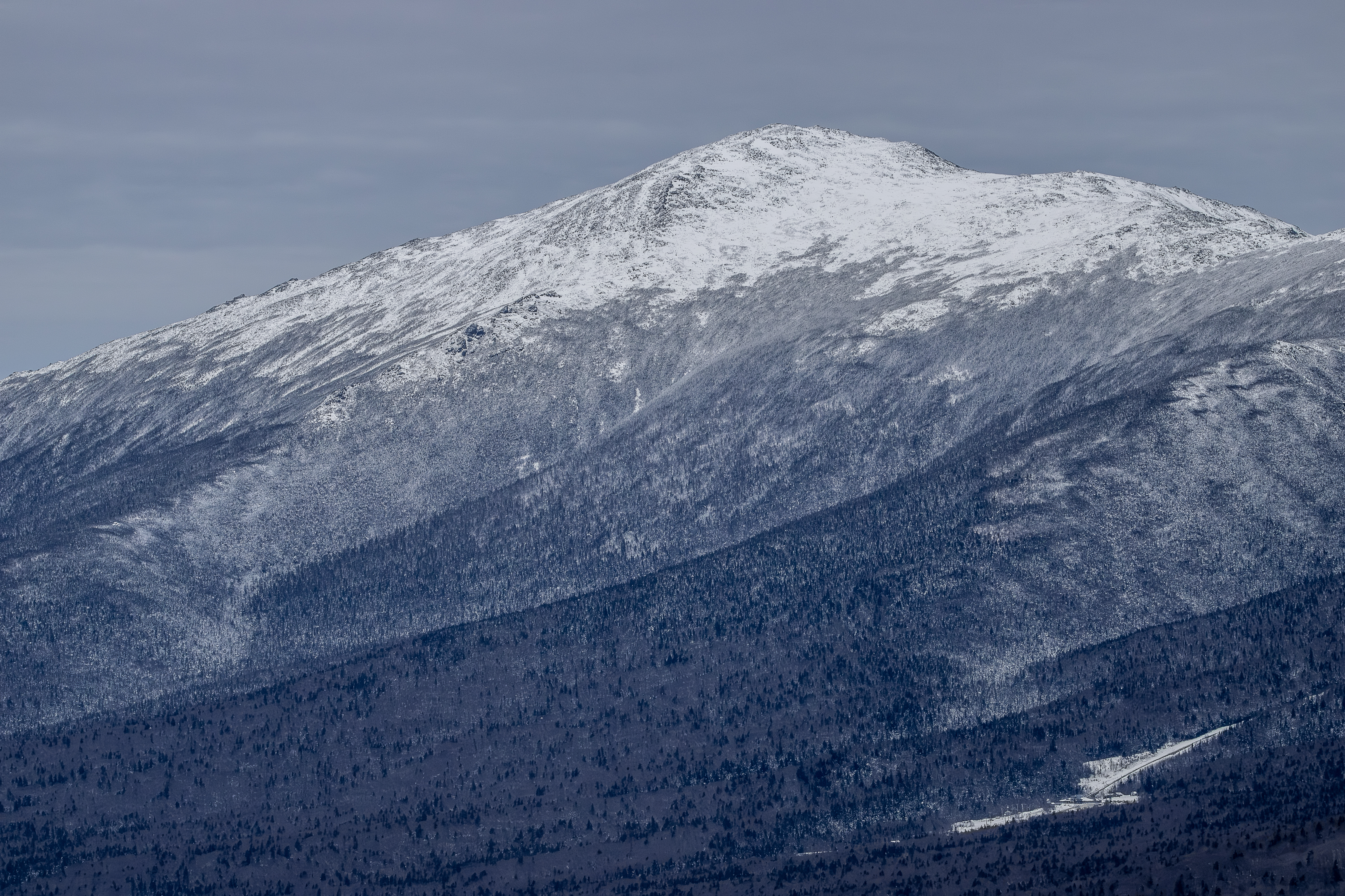 Snow-covered Mount Jefferson under cloudy winter sky in New Hampshire