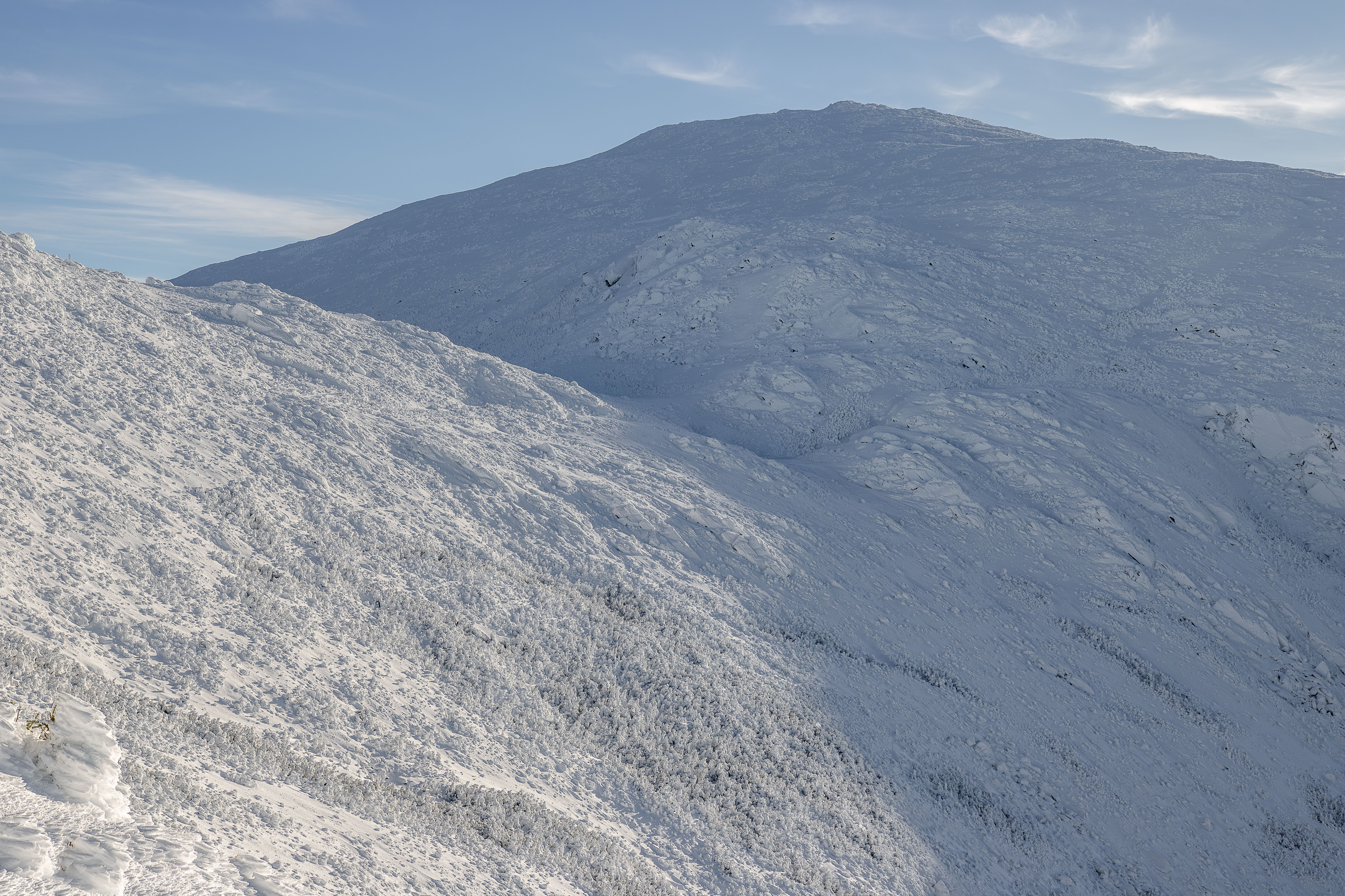 Mount Jefferson peak with light snow under clear blue sky in White Mountains